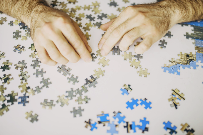 des mains qui assemblent des pièces de puzzle